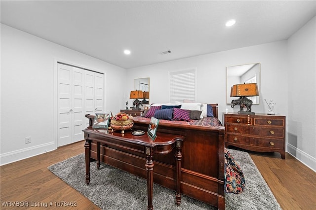 bedroom with dark hardwood / wood-style flooring and a closet