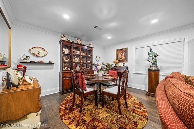 dining space with ornamental molding and dark hardwood / wood-style floors