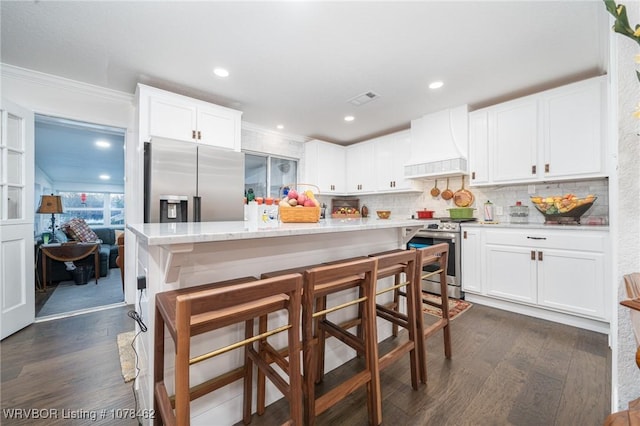 kitchen featuring custom exhaust hood, white cabinets, tasteful backsplash, and stainless steel appliances