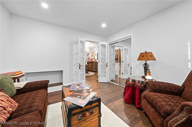 living room with hardwood / wood-style flooring, built in shelves, and french doors