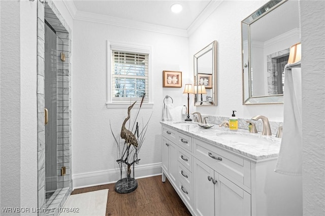 bathroom with crown molding, wood-type flooring, an enclosed shower, and vanity