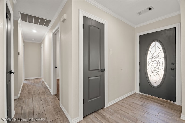 foyer featuring light wood-type flooring, visible vents, baseboards, and ornamental molding