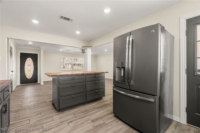 kitchen with baseboards, visible vents, wooden counters, wood finish floors, and stainless steel refrigerator with ice dispenser