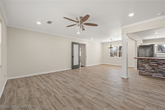 unfurnished living room with visible vents, plenty of natural light, light wood-type flooring, and ceiling fan