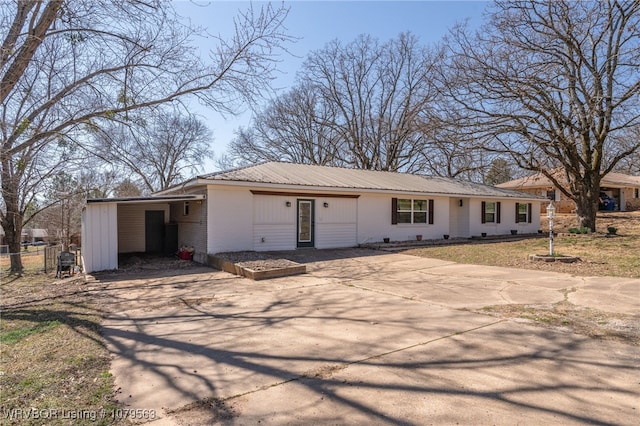 single story home featuring metal roof, brick siding, driveway, and fence