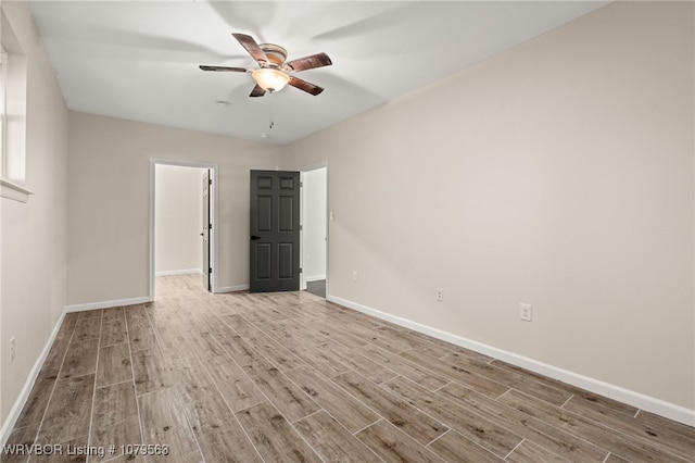 spare room with wood finished floors, baseboards, and ceiling fan