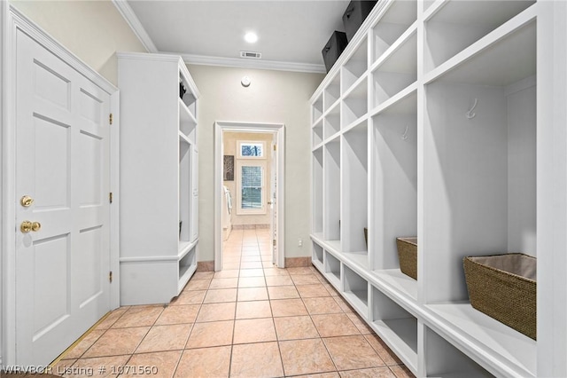 mudroom with light tile patterned floors and crown molding