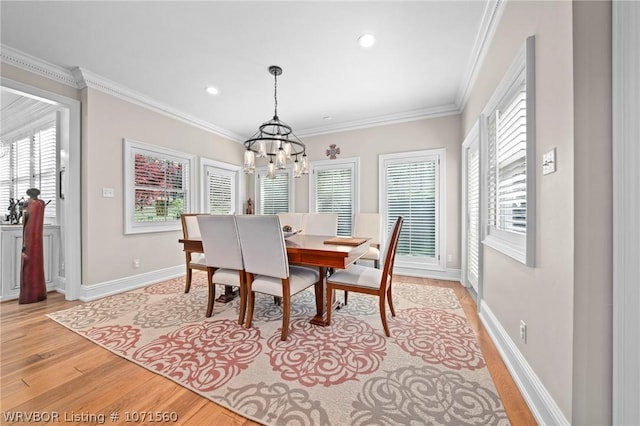 dining room featuring crown molding, an inviting chandelier, and light hardwood / wood-style flooring