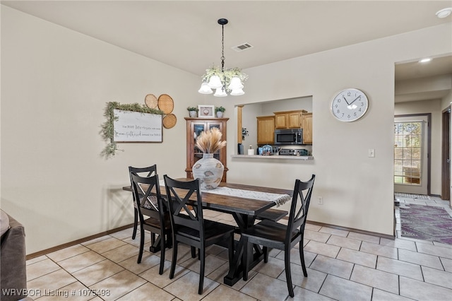 tiled dining area featuring a chandelier