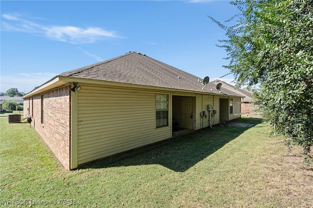 rear view of house with a yard and central air condition unit