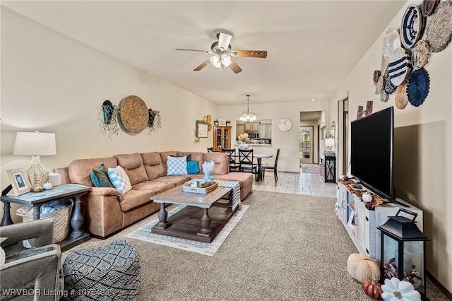 living room featuring light tile patterned flooring and ceiling fan with notable chandelier