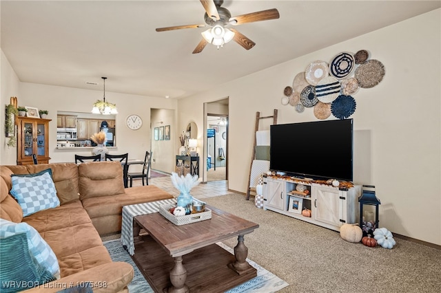 carpeted living room featuring ceiling fan with notable chandelier