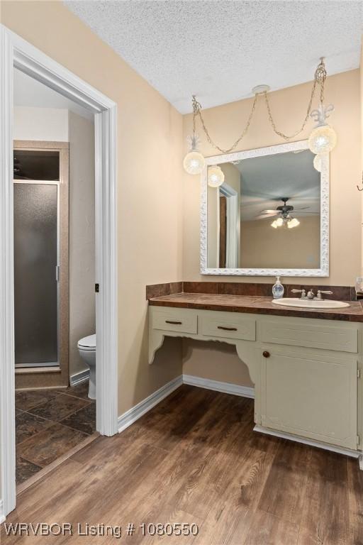 8611 Royal Ridge Dr, Fort Smith, AR 72903 - full bathroom featuring vanity, a shower stall, wood finished floors, ceiling fan, and a textured ceiling