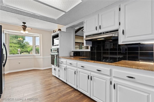 8611 Royal Ridge Dr, Fort Smith, AR 72903 - kitchen with wall oven, under cabinet range hood, white cabinets, tasteful backsplash, and a textured ceiling