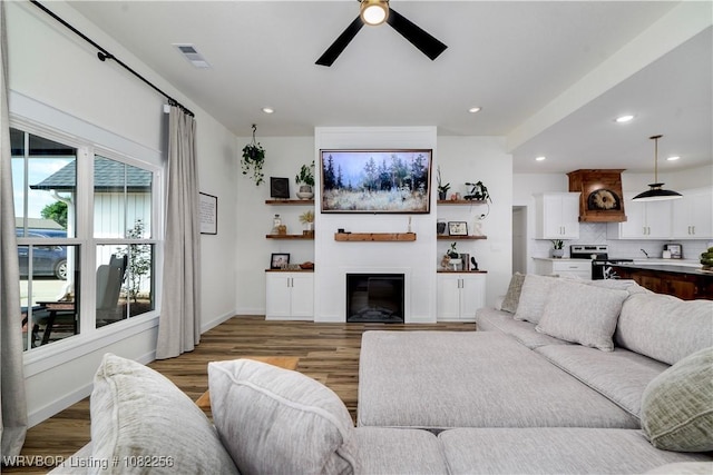 16312 Castle Rd, Poteau, OK 74953 - living room with a ceiling fan, light wood-style flooring, a glass covered fireplace, and recessed lighting