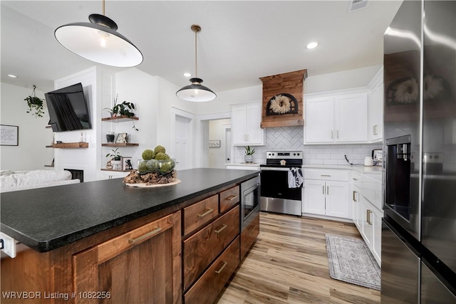 16312 Castle Rd, Poteau, OK 74953 - kitchen featuring appliances with stainless steel finishes, backsplash, white cabinets, light wood-style floors, and recessed lighting