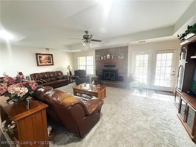 2103 W George, Pocola, OK 74902 - living area featuring a raised ceiling, light carpet, a fireplace, light tile patterned floors, and ceiling fan