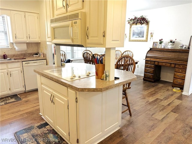 2103 W George, Pocola, OK 74902 - kitchen featuring white appliances, light wood-style flooring, a breakfast bar area, and light countertops