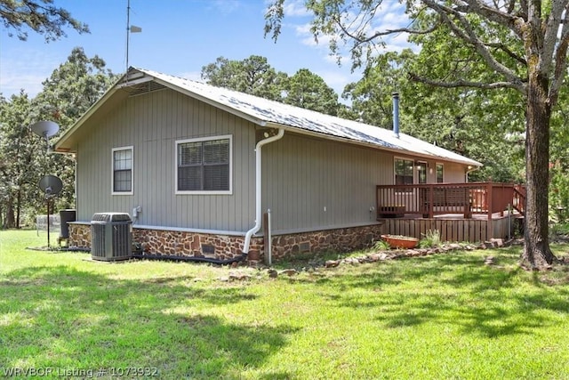 view of side of home with a yard, cooling unit, and a wooden deck