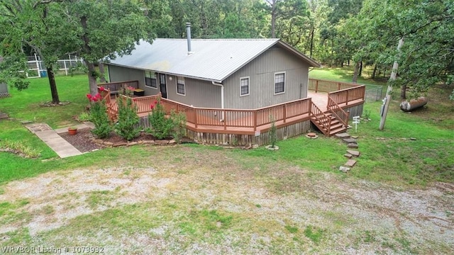 back of property featuring a wooden deck and a yard