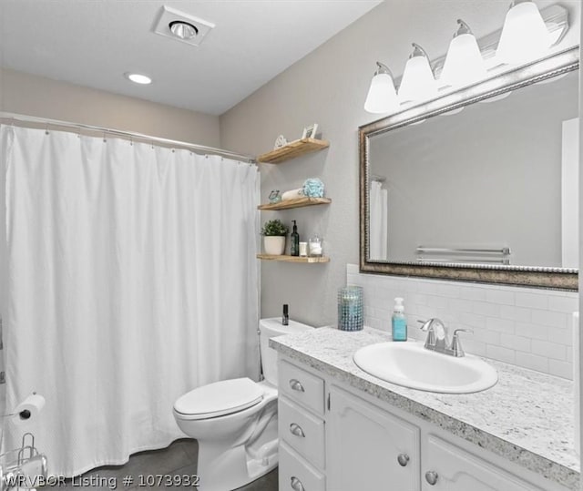 bathroom with vanity, tasteful backsplash, and toilet