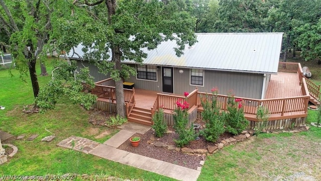 view of front of house with a front yard and a wooden deck