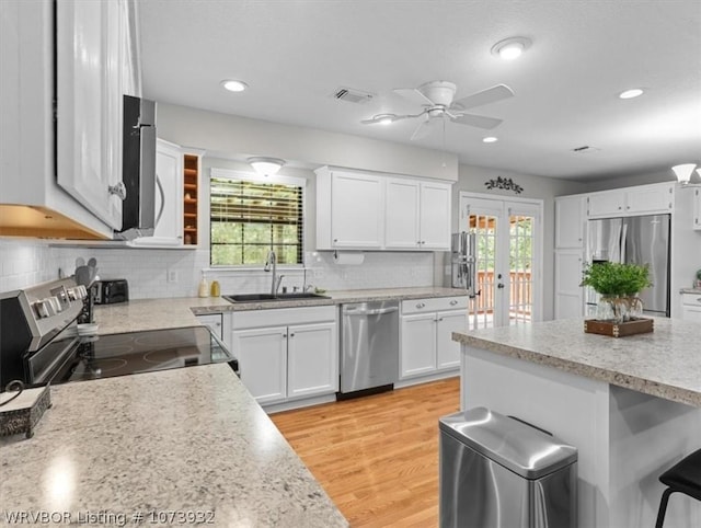 kitchen with ceiling fan, sink, stainless steel appliances, light hardwood / wood-style flooring, and white cabinets