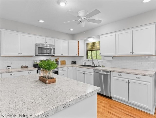 kitchen featuring white cabinets, appliances with stainless steel finishes, light wood-type flooring, and ceiling fan