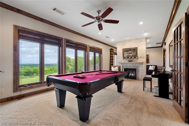 rec room with ceiling fan, a stone fireplace, billiards, light colored carpet, and ornamental molding