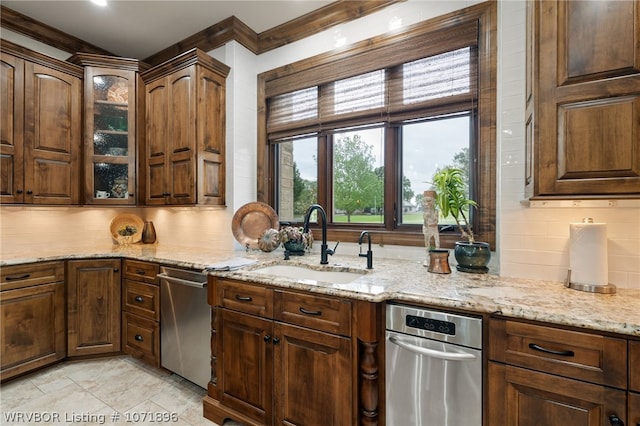 kitchen with backsplash, dishwasher, light stone counters, and sink