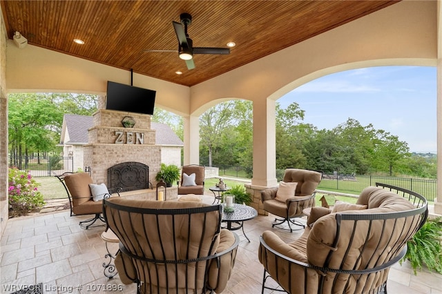 view of patio / terrace with an outdoor living space with a fireplace and ceiling fan