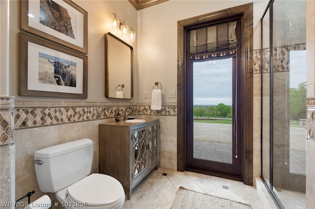 bathroom featuring tile patterned floors, vanity, tile walls, and toilet