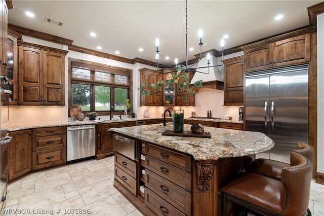 kitchen featuring tasteful backsplash, hanging light fixtures, a center island, and stainless steel appliances