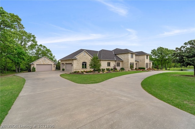 french country style house with a garage and a front lawn