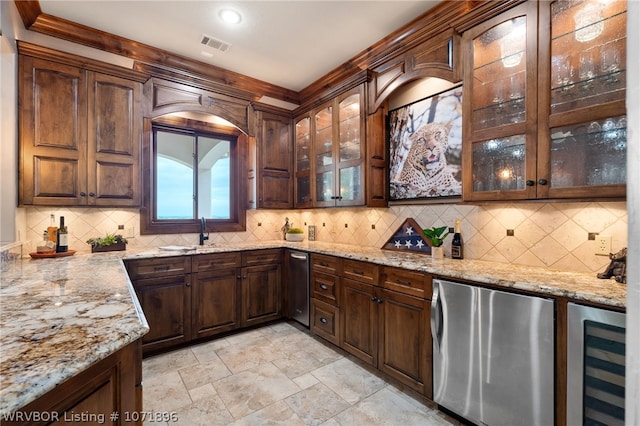 kitchen featuring wine cooler, light stone counters, and fridge