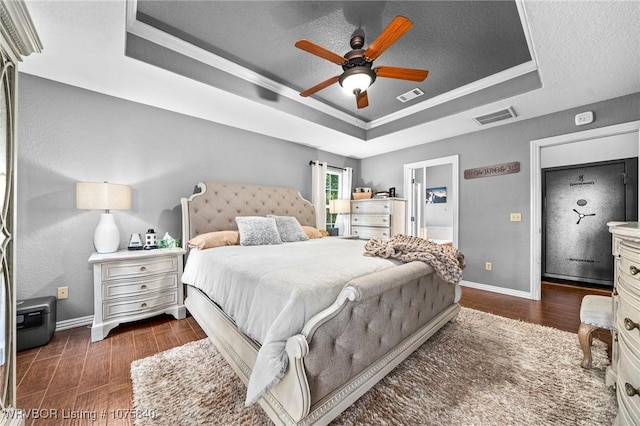 bedroom featuring a tray ceiling, ceiling fan, and ornamental molding