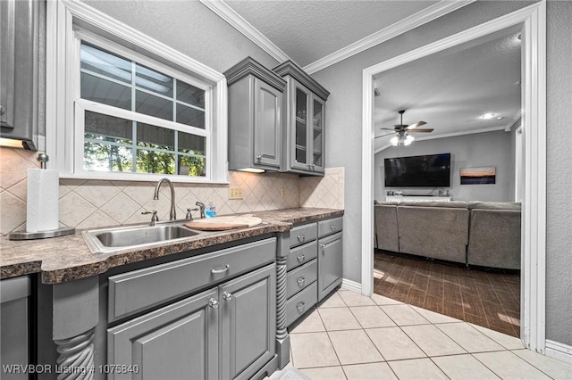 kitchen with backsplash, gray cabinets, ornamental molding, a textured ceiling, and light tile patterned flooring