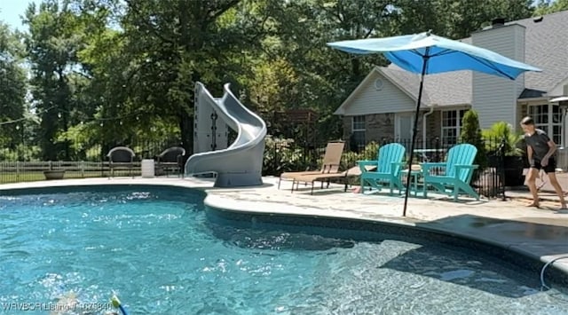 view of swimming pool featuring a water slide and a patio