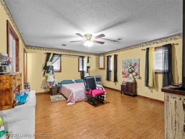 3204 W George, Pocola, OK 74902 - bedroom featuring light wood finished floors, a textured ceiling, and a ceiling fan