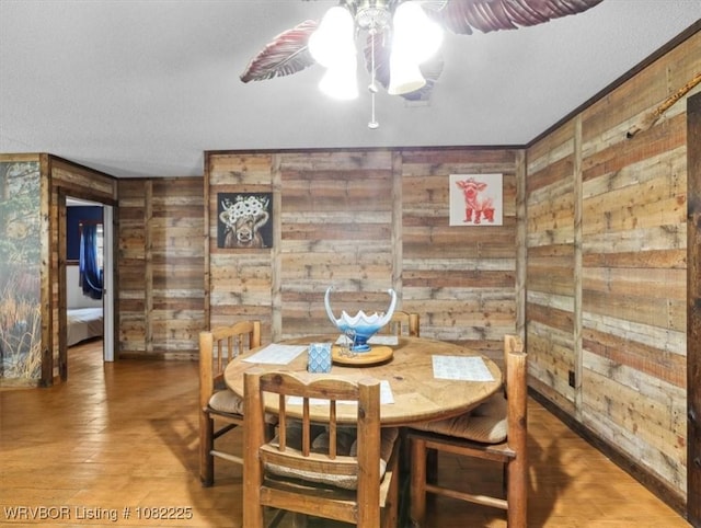 3204 W George, Pocola, OK 74902 - dining space with wooden walls, ceiling fan, and wood finished floors