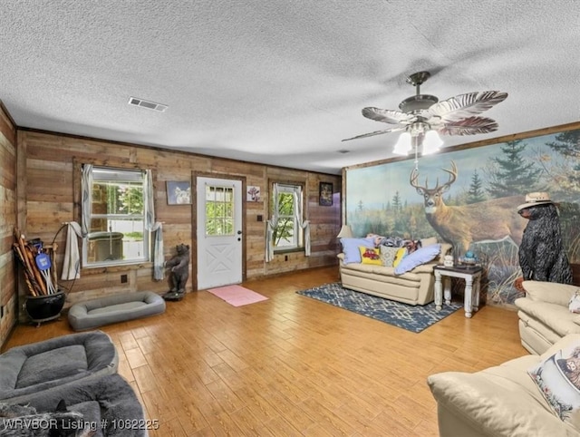 3204 W George, Pocola, OK 74902 - living area with a textured ceiling, wooden walls, a ceiling fan, and wood finished floors