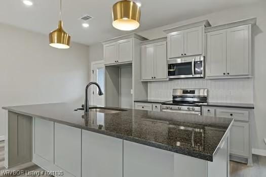 2018 Yellowstone Dr, Barling, AR 72903 - kitchen with stainless steel appliances, a sink, decorative backsplash, wood finished floors, and a large island
