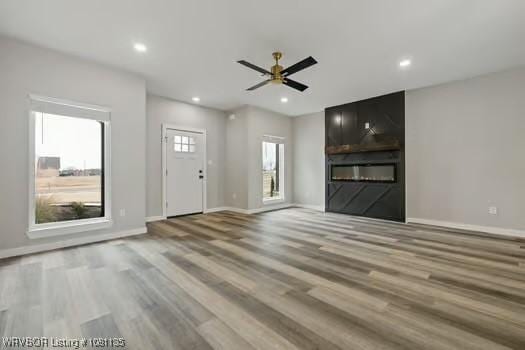 2018 Yellowstone Dr, Barling, AR 72903 - unfurnished living room featuring wood finished floors, recessed lighting, baseboards, and a large fireplace