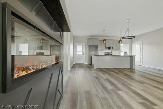 2018 Yellowstone Dr, Barling, AR 72903 - kitchen featuring stainless steel microwave, gray cabinets, range, wood finished floors, and baseboards