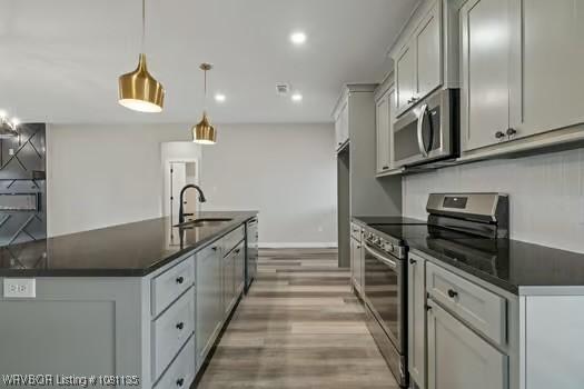 2018 Yellowstone Dr, Barling, AR 72903 - kitchen featuring stainless steel appliances, a sink, light wood-type flooring, an island with sink, and recessed lighting