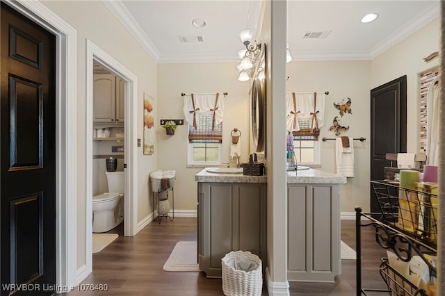 bathroom featuring hardwood / wood-style flooring, vanity, toilet, and crown molding