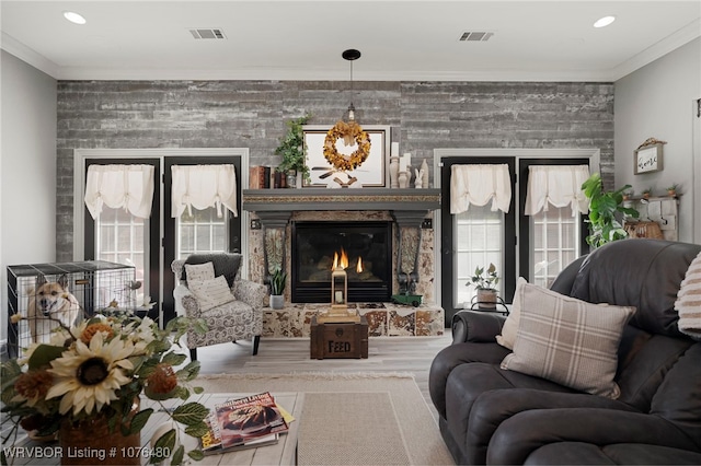 living area featuring ornamental molding and a fireplace