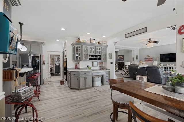 kitchen with gray cabinetry, stainless steel fridge, ceiling fan, and ornamental molding