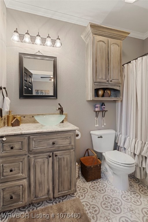 bathroom with tile patterned flooring, vanity, toilet, and crown molding