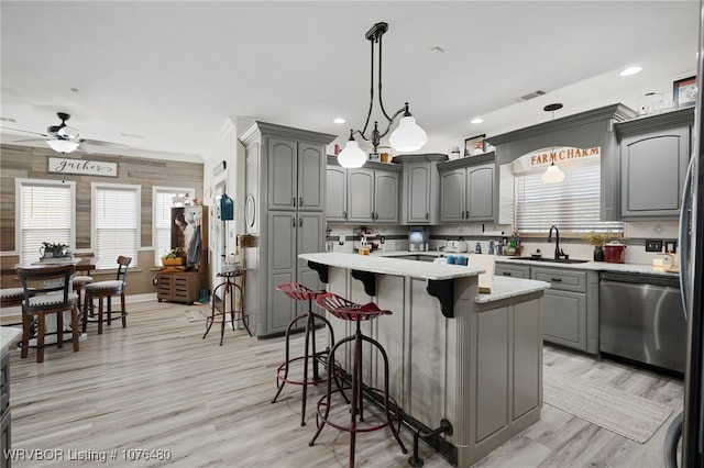 kitchen with gray cabinets, dishwasher, and a kitchen island